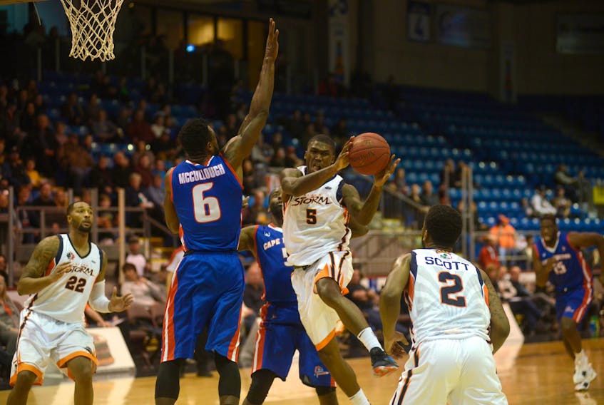 Island Storm guard Jarrell Tate penetrates and passes to teammate Tyler Scott while being defended by Cape Breton Highlanders O'Louis McCullough Saturday during the teams' first game of the National Basketball League of Canada regular season.