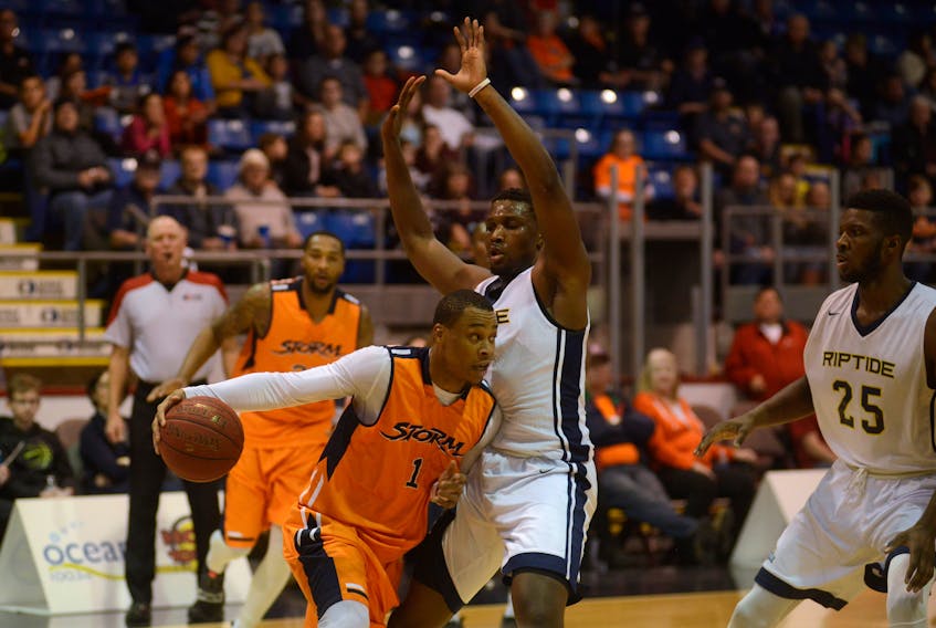 Island Storm guard Tyree White drives base-line to the basket while being defended by Saint John Riptide point guard Brent Arrington Sunday at the Eastlink Centre.