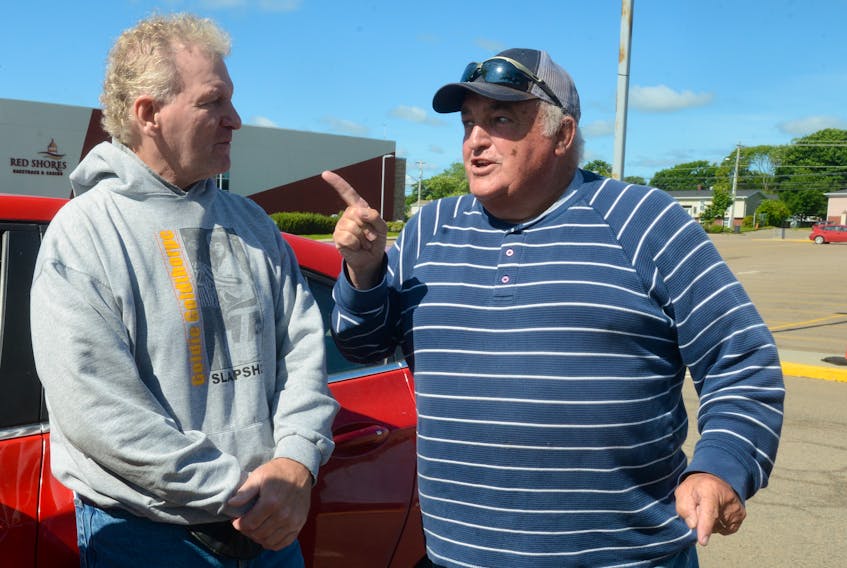 Jamie Kennedy, left, shares a story with his former teammate, Bill (Goldie) Goldthorpe, Thursday at Red Shores at the Charlottetown Driving Park.