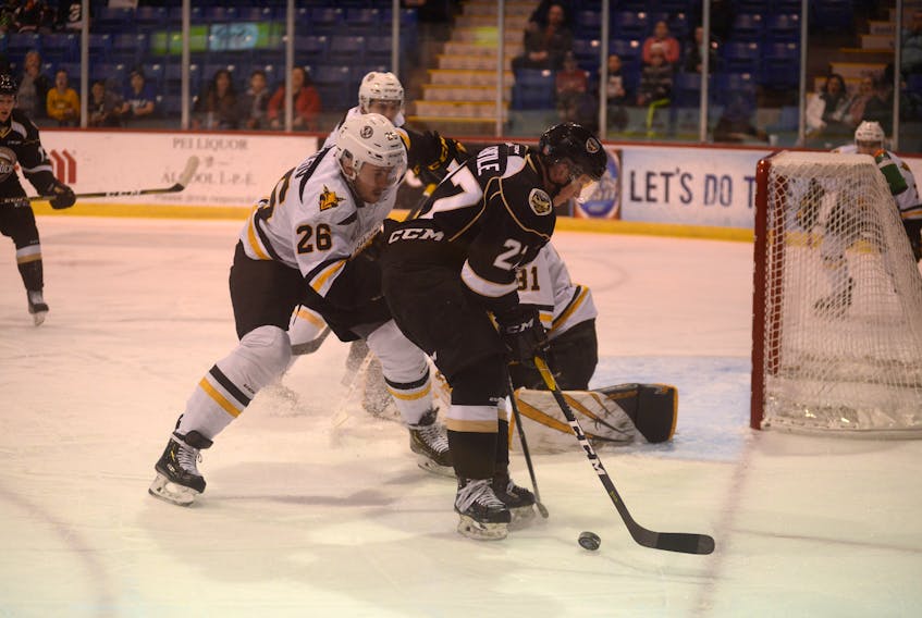 Charlottetown Islanders forward Derek Gentile tries to settle a rolling puck at the side of Cape Breton Screaming Eagles goaltender Kevin Mandolese's net while being defended by left-winger Egor Sokolov Saturday during Quebec Major Junior Hockey League action at the Eastlink Centre in Charlottetown.