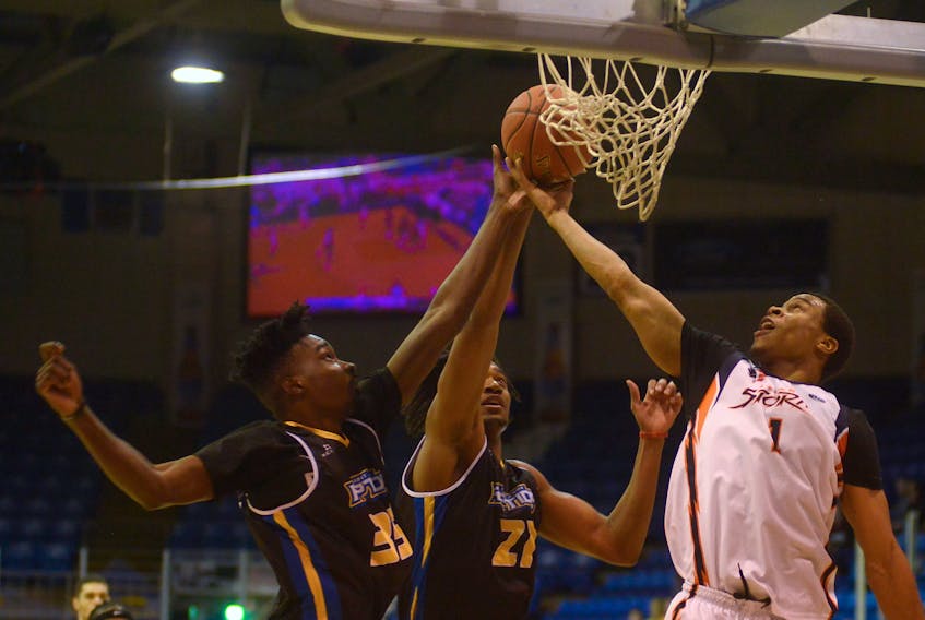Island Storm guard Tyree White, right, battles a pair of Saint John Riptide players for a rebound Thursday during National Basketball League of Canada action at the Eastlink Centre.