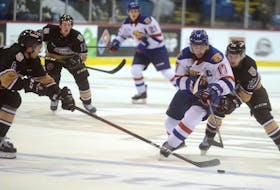 Charlottetown Islanders' centre Zac Beauregard, right, tries to lift the stick of Moncton Wildcats' captain Gabriel Fortier during Saturday's Quebec Major Junior Hockey League game at the Eastlink Centre.
