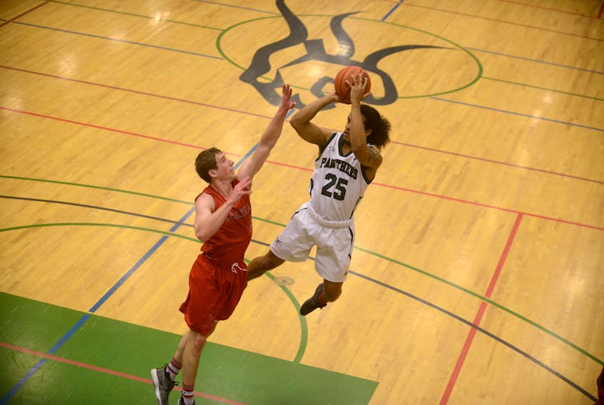 UPEI Panthers guard Nudy Georges takes a shot over Ben Miller of the Acadia Axemen Friday during Atlantic University Sport basketball in Charlottetown.