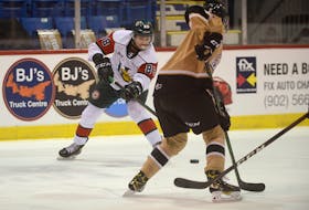 Halifax Mooseheads right-winger Bobby Orr, left, feeds the puck through Charlottetown Islanders defenceman Will Trudeau during Friday's Quebec Major Junior Hockey League contest at the Eastlink Centre in Charlottetown.