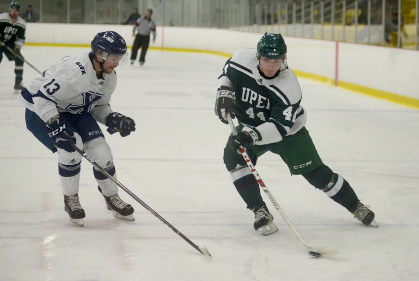 UPEI Panthers rookie forward Luke Kirwan, right, tries to cut to the net while being defended by St. FX X-Men defenceman Adam Holwell Tuesday during Atlantic University Sport men's hockey action at MacLauchlan Arena.
