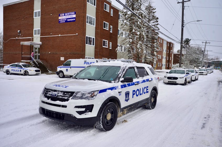At least nine police vehicles are parked outside an apartment building on Roleika Drive in Dartmouth on Wednesday morning, Dec. 18, 2019, after a man was taken to hospital with life-threatening stab wounds.