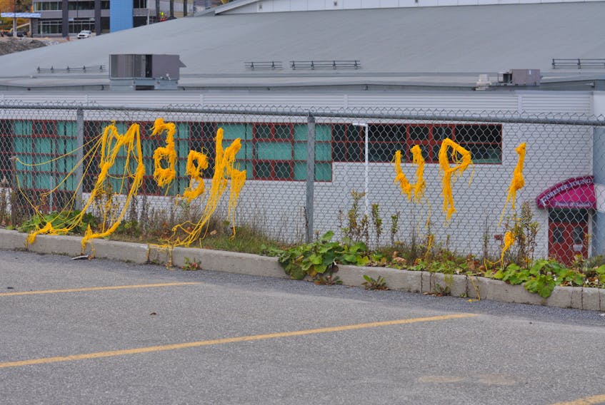 A bright yellow yarn bomb reminder to wear a face mask was strung along a fence at Grenfell Campus in Corner Brook recently.
