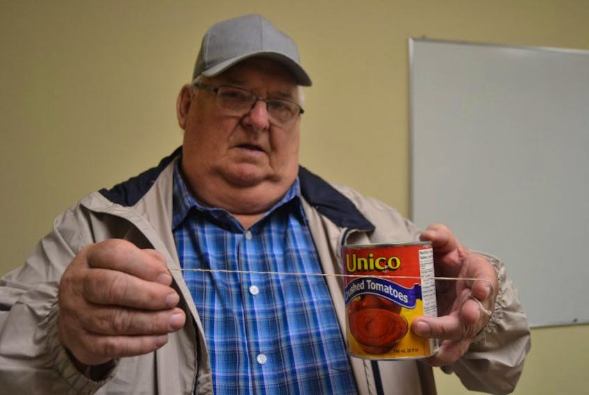 Charlottetown resident Stuart Thompson shows a string he found in a can of Unico crushed tomatoes. After making several calls to the company and not receiving a response, he wants to make the public aware of his experience.