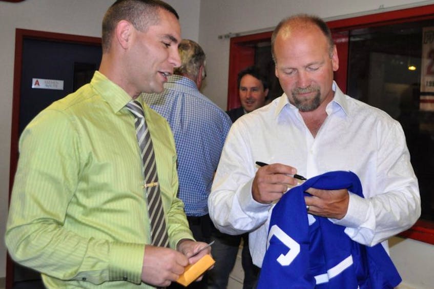 Wendel Clark autographs a sweater for a fan during a pre-dinner reception in the Hall of Fame Room at Acadia Arena