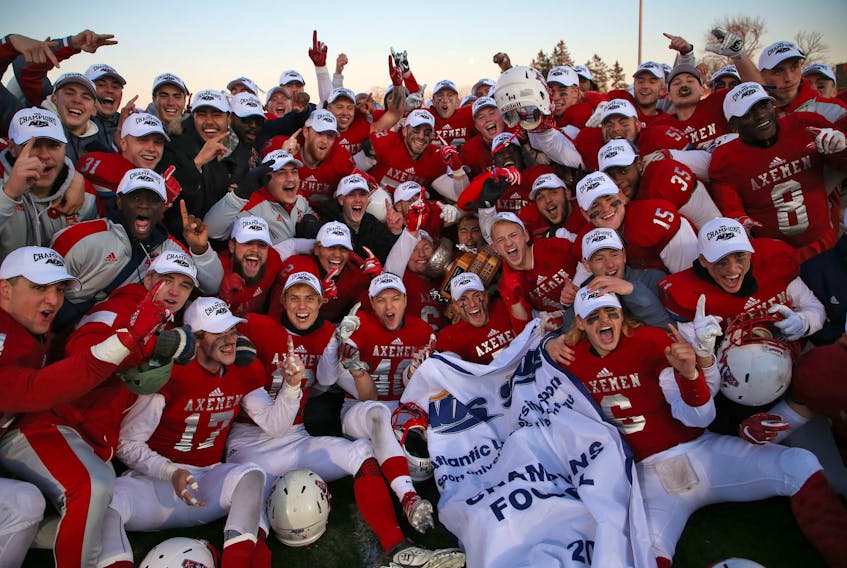 The Acadia Axemen celebrate after capturing the Loney Bowl conference championship on Saturday afternoon in Wolfville. The Axemen defeated the Bishop's Gaiters 31-1 for their 15th AUS title.
