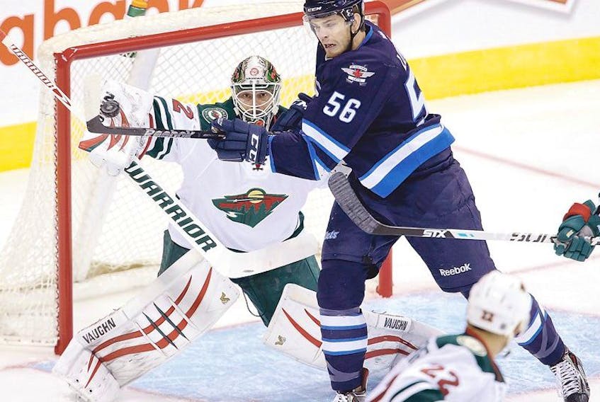 The Winnipeg Jets’ Adam Lowry (56) tries to deflect the puck past Minnesota Wild goaltender Niklas Backstrom (32) during the teams’ pre-season game in Winnipeg earlier this week. Last year, Lowry, the Jets third-round pick in 2011, had 17 goals and 33 points in 64 games for the St. John’s IceCaps in his rookie season.