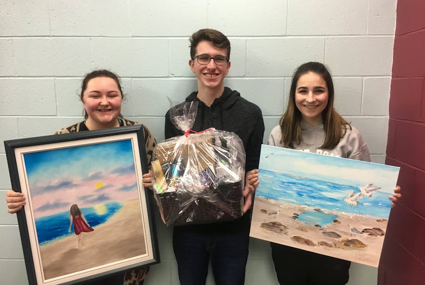 Students put in many hours volunteering with the auction. From left are Emily Swansburg, Dylan Rhyno and Lauren Amirault with some of the items donated for the event.
