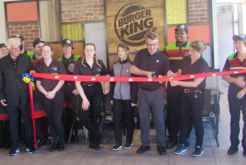 Burger King staff gather to cut the ribbon to celebrate the newly renovated restaurant in New Minas.