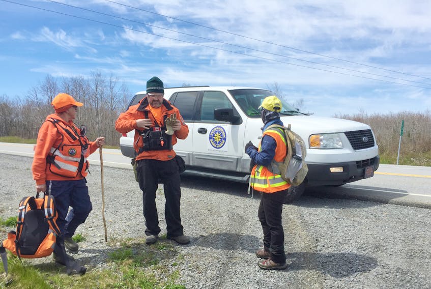 Members of the May 12 search and rescue effort take a breather along Highway 103 in Liverpool.