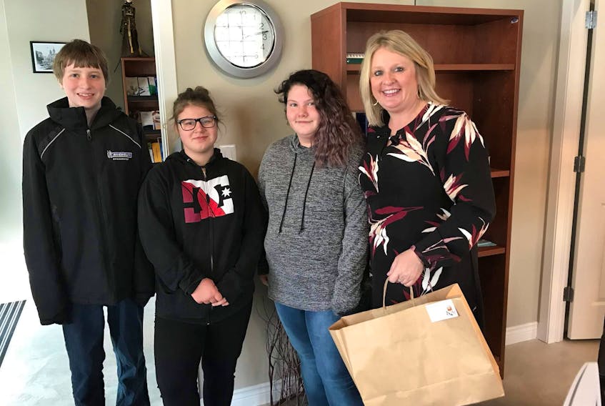 MLA Kim Masland recently made a donation to the South Queens Middle School Holiday Merchandise Bingo event being held on Dec. 10 at the Liverpool Fire Hall.  She is pictured with students Isaiah Delong, Kayleigh Gibson-Whynot and Tamara Uhlman.