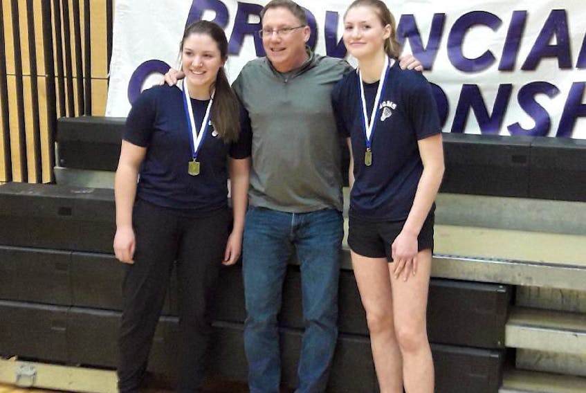 Marah Mitton (left) and Maggie Hadskis (right) stand with their coach Greg Killam, after having won the provincial girls doubles junior team badminton championship. They placed second at the districts which got them to regionals where they placed second, which got them to provincials where they won. Both girls have been coached by Killam for the past three years.
