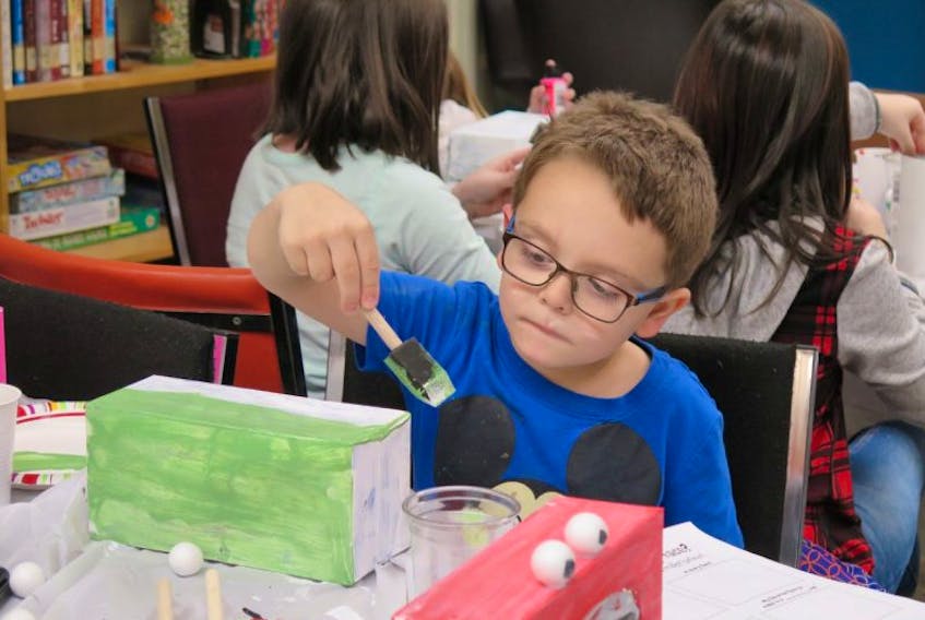 RJ (Reggie) White was one of the participants in the Winter Family Program at the Buchans Public Library by intern Melissa Quirk Her first event included a story time and a craft - a decorated tissue box that RJ painted before adding ears, nose and eyes.
