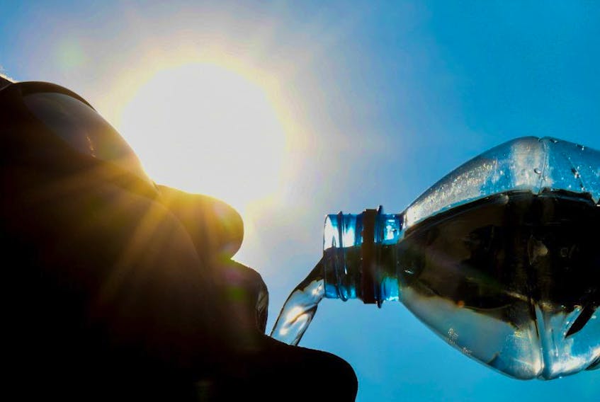 A man poses while drinking from a water bottle on a hot day. DENIS CHARLET/AFP/Getty Images file