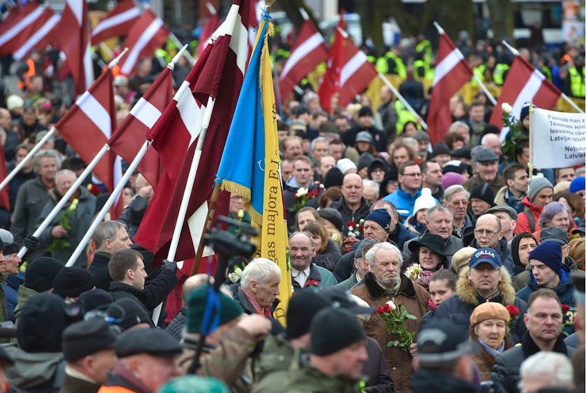 Veterans of the Latvian Legion, a force that was commanded by the German Nazi Waffen SS during WWII, and their sympathizers carry flowers as they walk to the Monument of Freedom in Riga, Latvia on March 16, 2016 to commemorate a key 1944 battle in their ultimately failed attempt to stem a Soviet advance. Jewish groups, Moscow and some in Latvia's ethnic-Russian community see the parade as glorifying Nazism because the Legion, founded in 1943, was commanded by Germany's Waffen SS, the armed wing of the Nazi party's Schutzstaffel SS (Protective Squadron). / AFP / afp / Ilmars Znotins