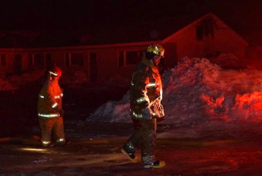 Kensington Volunteer Fire Department members make thier way to trucks in front of the Clermont Apartment complex in New Annan, after spending several hours in wind and cold fighting a fire that had invaded the open attic of the building. Approximately 20 apartments were evacuated, with the residents being housed overnight in Kensington until further arrangements could be made.