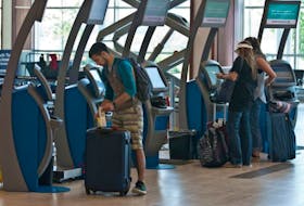 WestJet passengers check in using the Halifax Stanfield International Airport's new self-serve baggage kiosks last July.