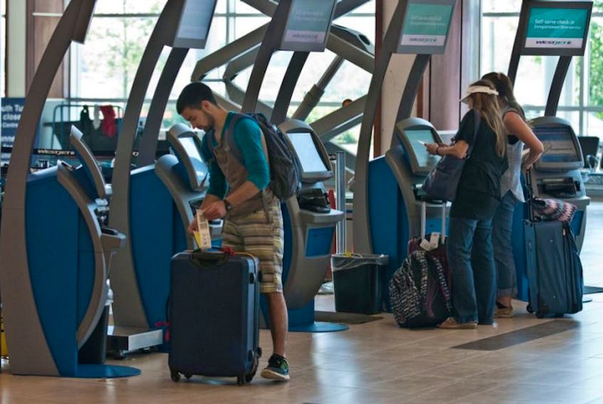 WestJet passengers check in using the Halifax Stanfield International Airport's new self-serve baggage kiosks last July.