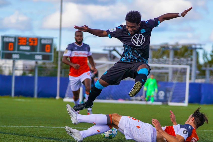 HFX Wanderers FC striker Akeem Garcia leaps over the tackle of Forge FC's Daniel Krutzen during Saturday's CPL championship game in Charlottetown. (CANADIAN PREMIER LEAGUE)