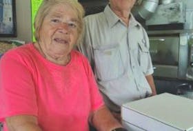['Alice Xiros, 82, of Alice’s Pizza would still be working if you could. She stands in the shop, which closed a year ago, with her husband Bob. PHOTO BY ROSALIE MACEACHERN']