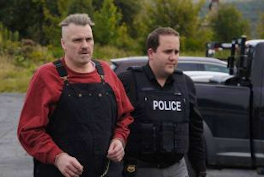 ['An RCMP officer escorts Allan Winfield Potter outside Harbour Grace Provincial Court in this file photo.']