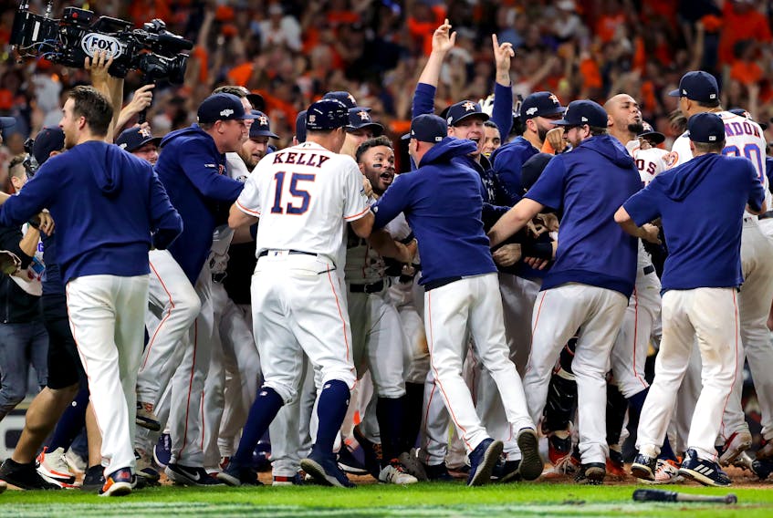 Houston Astros players mob Jose Altuve following his ninth-inning walk-off two-run home run in Game 6 on Saturday night to defeat the New York Yankees in the ALCS. (Elsa/Getty Images)