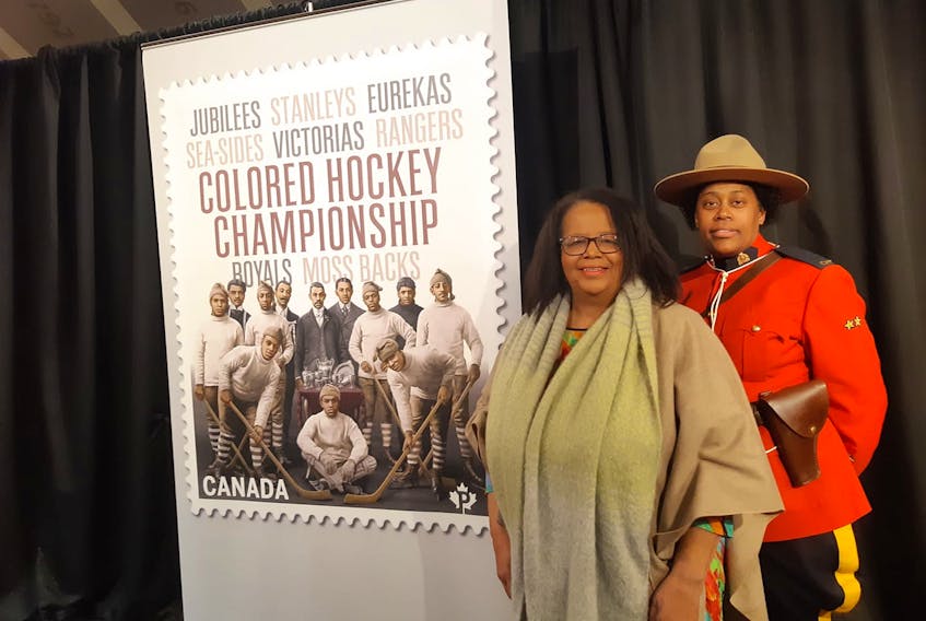 Elizabeth Cooke-Sumbu, executive director of the Cumberland African Nova Scotian Association, and Halifax RCMP officer Natasha Thomas stand beside a giant copy of a Canada Post stamp unveiled Jan. 23 that celebrates the Coloured Hockey League of the late 19th and early 20th century. Her grandfather, Fred Cooke, played for the Amherst Royals. Contributed