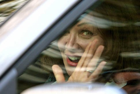Barbara Amiel waves to the media as she drives away from her and Conrad Black's home in Toronto on May 4, 2012.
