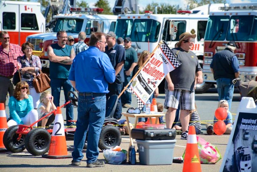 Bill Dowe (centre), event organizer, calls a trucker over to take part in the MADD Kart Challenge.
