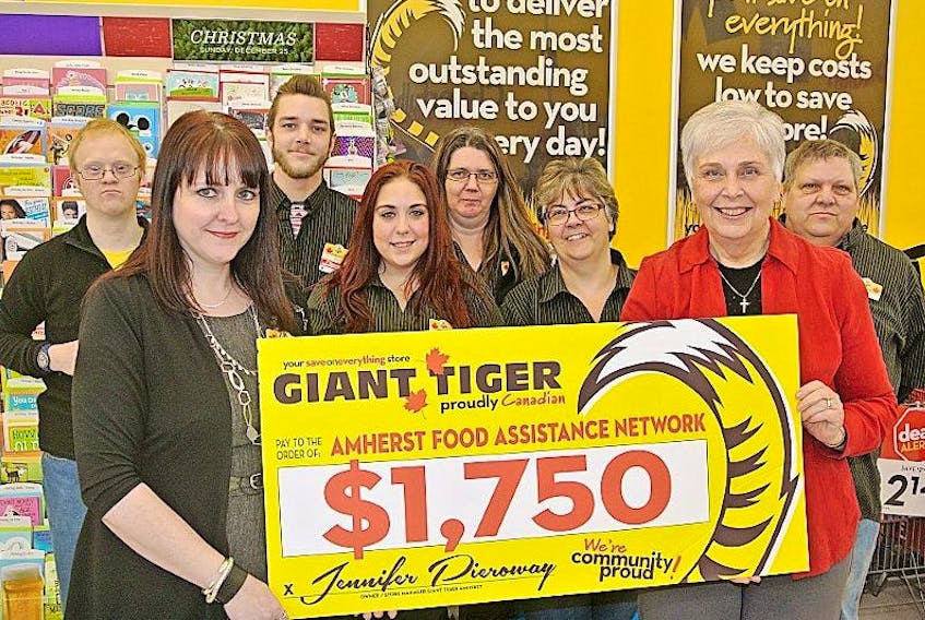 Giant Tiger Amherst store manager Karen Pieroway (left) presents a $1,750 to Rev. Charlotte Ross of the Amherst Food Assistance Network while Giant Tiger employees look on.