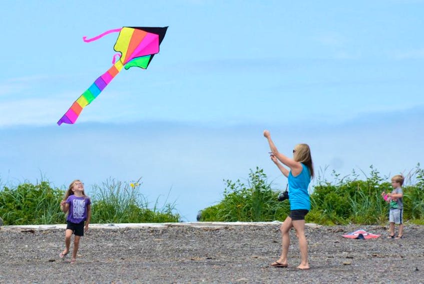 Six-year-old Sophia watches as her mom Heidi gets the kite up in the air.
