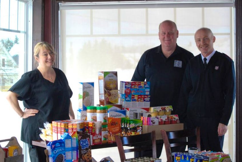 Sociables Pub & Eatery lead the charge to help Springhill’s local food bank, with (from left) Trudy Harrison and Brent MacDonald presenting food and cash donations to the Salvation Army’s Stephen Toyton on Feb. 17. 

