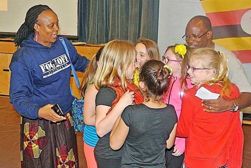 Students at Spring Street Academy rush to greet Caleb Twinamatsiko and his wife, Hope, from Bishop McAllister College in Uganda. Students at the Amherst school have been raising money over the last three years to purchase sports equipment, desks and art supplies for students at the school in Uganda. The Twinamatsikos were in Amherst on Friday to say thanks.