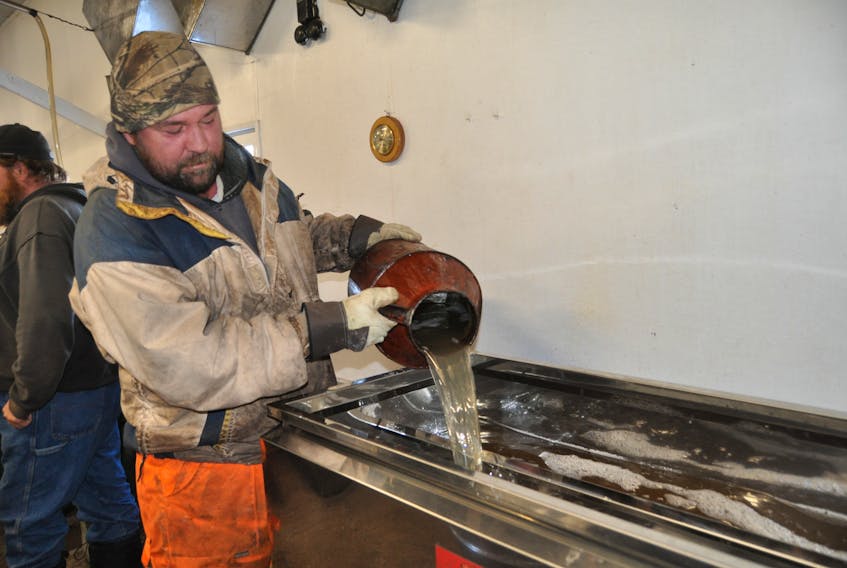 Frankie Mitchell pours the latest batch of maple syrup at Dickinson Bros. Maple Products in West Brook.