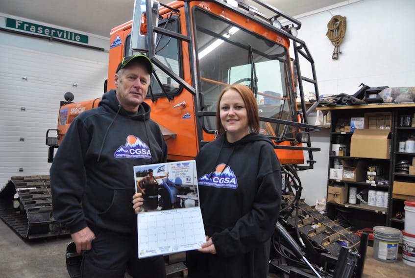 Mike Fraser and Amanda Hanham are pleased with the Chignecto Glooscap Snowmobile Association’s latest fundraising project, a 2018 calendar featuring several of the members wearing little more than smiles.