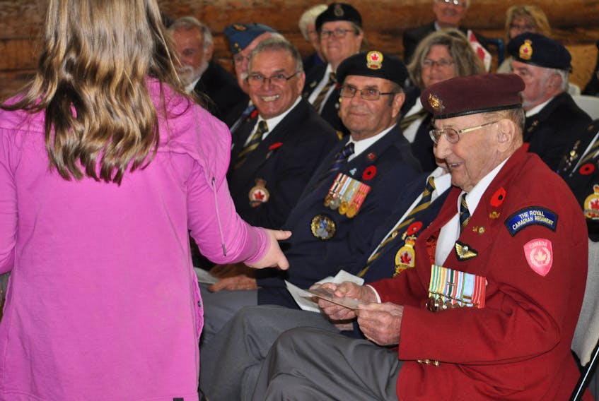 Korean War veteran Roy Fletcher accepts one of the postcards given out by children at Advocate’s Remembrance Day ceremony at the log building on Sunday, Nov. 5.