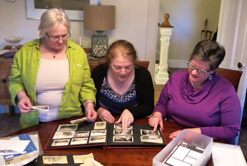 (From left) Eleanor Crowley, Tracy Black and Alison Draper of the Oxford Historical Society review photos during a recent work night meeting.