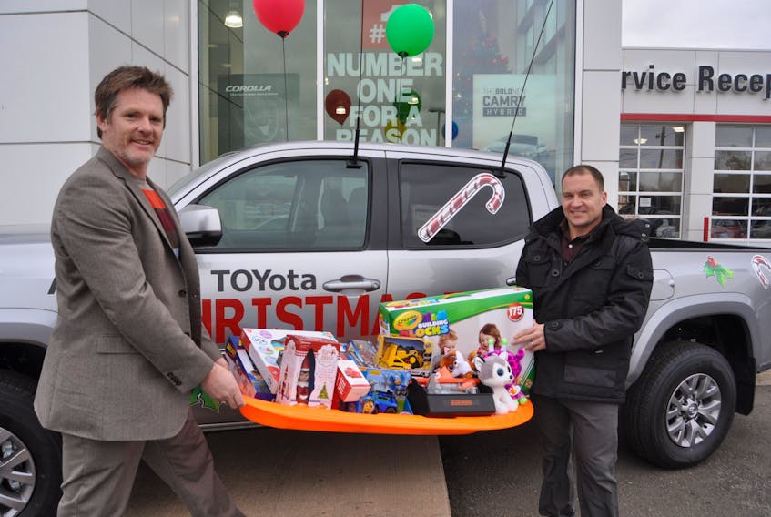 Glenn Roberts (left) and Troy Williams at Amherst Toyota show some of the toys collected so far in their annual toy drive for Christmas for Kids. The toy truck will be back in action at the Christmas parade in Oxford on Nov. 24.