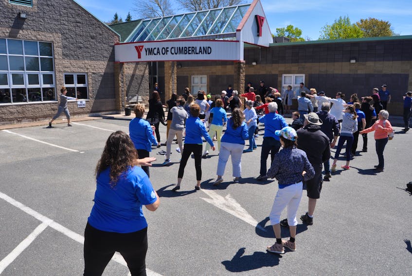 The first “Let’s Walk About It” walk for mental health awareness took place in Amherst today, with a crowd of participants taking part in loops of the Big Block Walk before gathering back at the Cumberland YMCA for lunch at the community kitchen. Laura Farrow led the group in a warm-up prior to the walk.