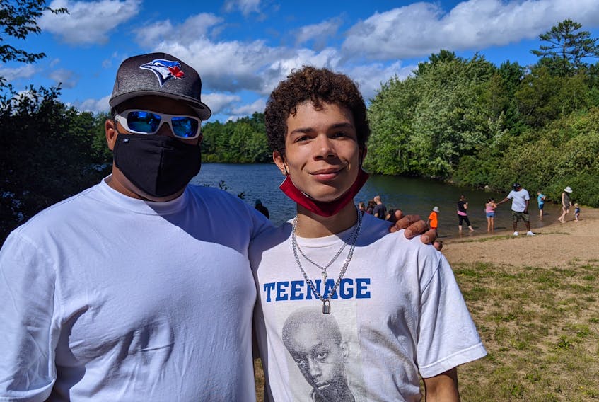 Greg Dean and Peter Fisk, the 17-year-old co-organizer of an anti-racism beach picnic Sunday, enjoy the event at Hutt Lake in Chester Basin. The picnic was sparekd by a racist threat involving a noose against Dean and his family at the beach earlier this month.