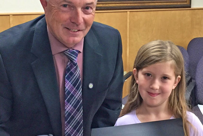 Municipality of the County of Antigonish Warden Owen McCarron gives Kenzie Gormley some gifts during a Sept. 17 presentation. County council honoured the youngster for her initiative Kenzie’s Backpacks, which provides school supplies to children in need. Corey LeBlanc