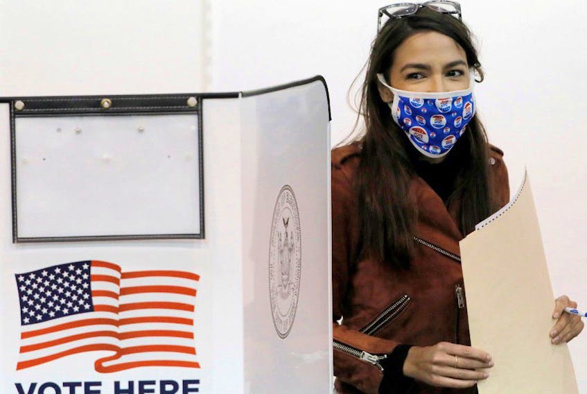 Congresswoman Alexandria Ocasio-Cortez holds her filled ballot as she votes early at a polling station in New York City, on Oct. 25.