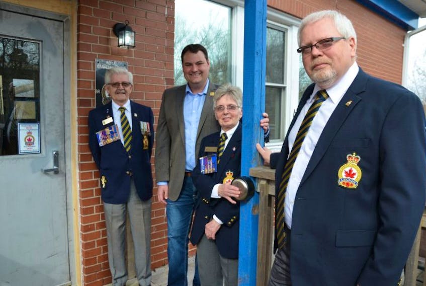 Service Officer Constance Bohaker pushes the button to the newly installed automatic door at the Port Royal Legion in Annapolis Royal while West Nova MP Colin Fraser looks on. Left is Ron Bohaker and right is Mike Kayo.