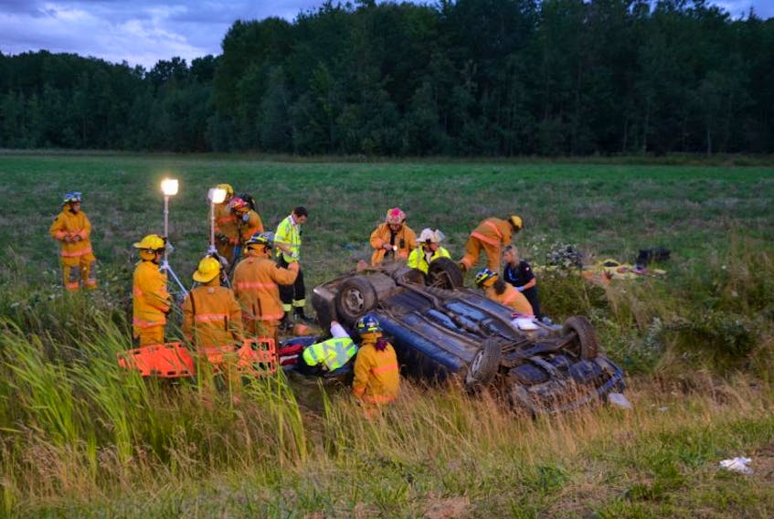Lawrencetown and Middleton firefighters work with paramedics to free a man trapped in a car that crashed in the ditch on Highway 101 a few hundred metres east of Exit 19 at Lawrencetown in Annapolis County Sunday evening. Life Flight was called to the scene but took off without the victim who was later placed in an ambulance.