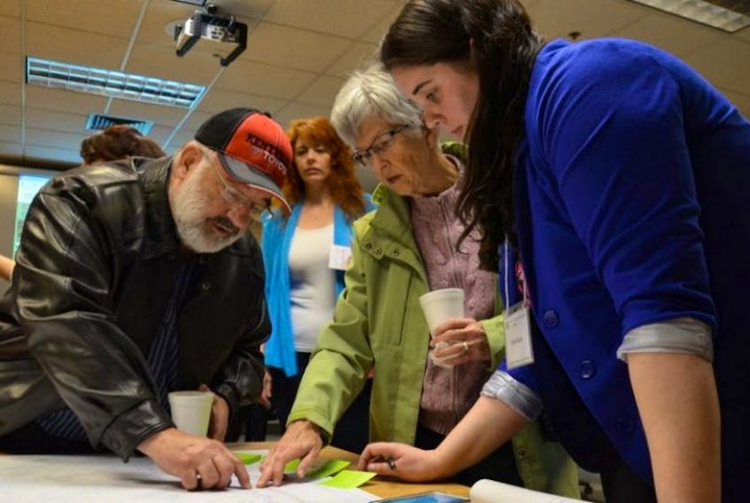 COGS student Katie Chute, right, looks at a map with several community members who are writing down suggestions to place on the digital version at an information session in Lawrencetown last year to unveil the Annapolis Community Mapping Project. This year’s session is April 13 from 1 to 3 p.m. at the college.