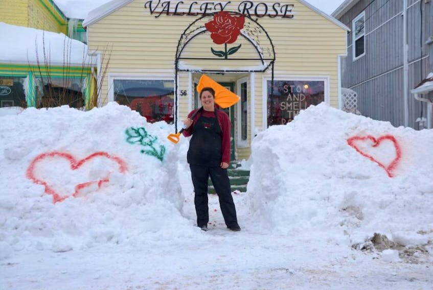 Home Hardware saved Valentine's Day in Middleton this year. Sabrina Tapp of Valley Rose flower shop faced a mountain of snow when she arrived at work this morning, one of the busiest days of the year for a florist. But some neighbours soon came to the rescue from Home Hardware just across the street. Anne Callanan, Joan Penny, and Emily Shorey brought shovels from the hardware store and helped clear an eight-foot path through the four-foot-deep snow to the flower shop's door. Not only that, the Home Hardware staff dug out some spray calk and painted open signs, hearts, and flowers in the snow banks so people would know Middleton was open for business after Monday's snow storm. Customers driving by couldn't tell if businesses were open because of the mountains of snow.